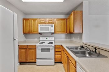 A kitchen with wooden cabinets and white appliances.